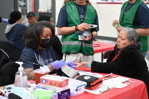 An AMEN volunteer takes vitals for one of the free clinic attendees.