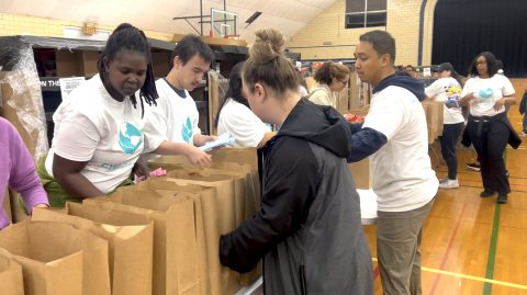 Andrews University students helped stuff bags in one of the gift assembly lines on Change Day. Videographic image recorded by Pastor Michael Kusarawana. 
