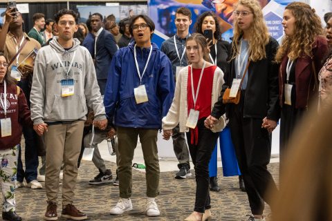 A group of attendees broke welcomed the Sabbath by joining hands and singing a hymn in the exhibit hall. [Photo: Samuel Girven]