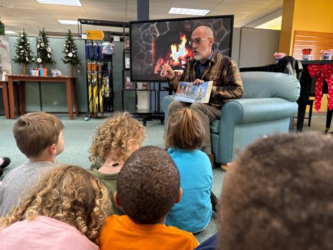 Children from The Crayon Box listen to a story.
