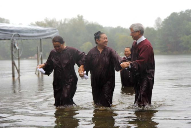 Among the group baptized was a former shaman, Pa-chia Fa (right). The rain could not dampen the spirit of rejoicing.  “Since coming to the Adventist Church I have found so much happiness,” she explained. “I’m so happy I don’t have words to express. I am so grateful that even though I am very old, Jesus still wants to help me.”