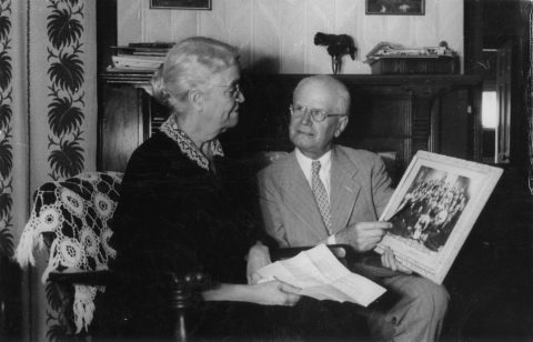 Walter S. Mead and Laura Foster Rathbun looking at a picture at the 50th anniversary of the ninth-grade class of Battle Creek College Prepatory of which Laura was English teacher and Walter a pupil. Photo courtesy Center for Adventist Research