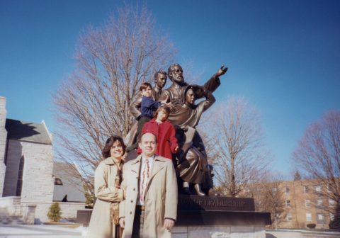 The DePaiva family moved from Brazil to Berrien Springs for Ruimar (front right) to attend Andrews University. They are pictured here in 2002 in front of the J.N. Andrews statue by Pioneer Memorial Church.