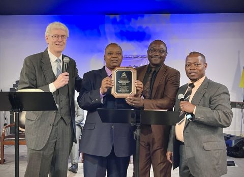 Golden Gate, pictured here with leaders receiving a plaque commemorating their transition from group to company status, is not yet an official church, although they are well on their way. The time frames for both Elwell and Golden Gate, explains Stewart, are average for a company. However, for a refugee company, this is exceptional. Pictured from left to right: Bob Stewart (Michigan Conference Refugee and Immigrant Ministries Director), Wilson Sembeba (Stand-in pastor for Golden Gate Company), Pastor Yosef Imam (A significant leader within the Golden Gate congregation), and Benjamin Mugisa (Elder and clerk for the Golden Gate Company).